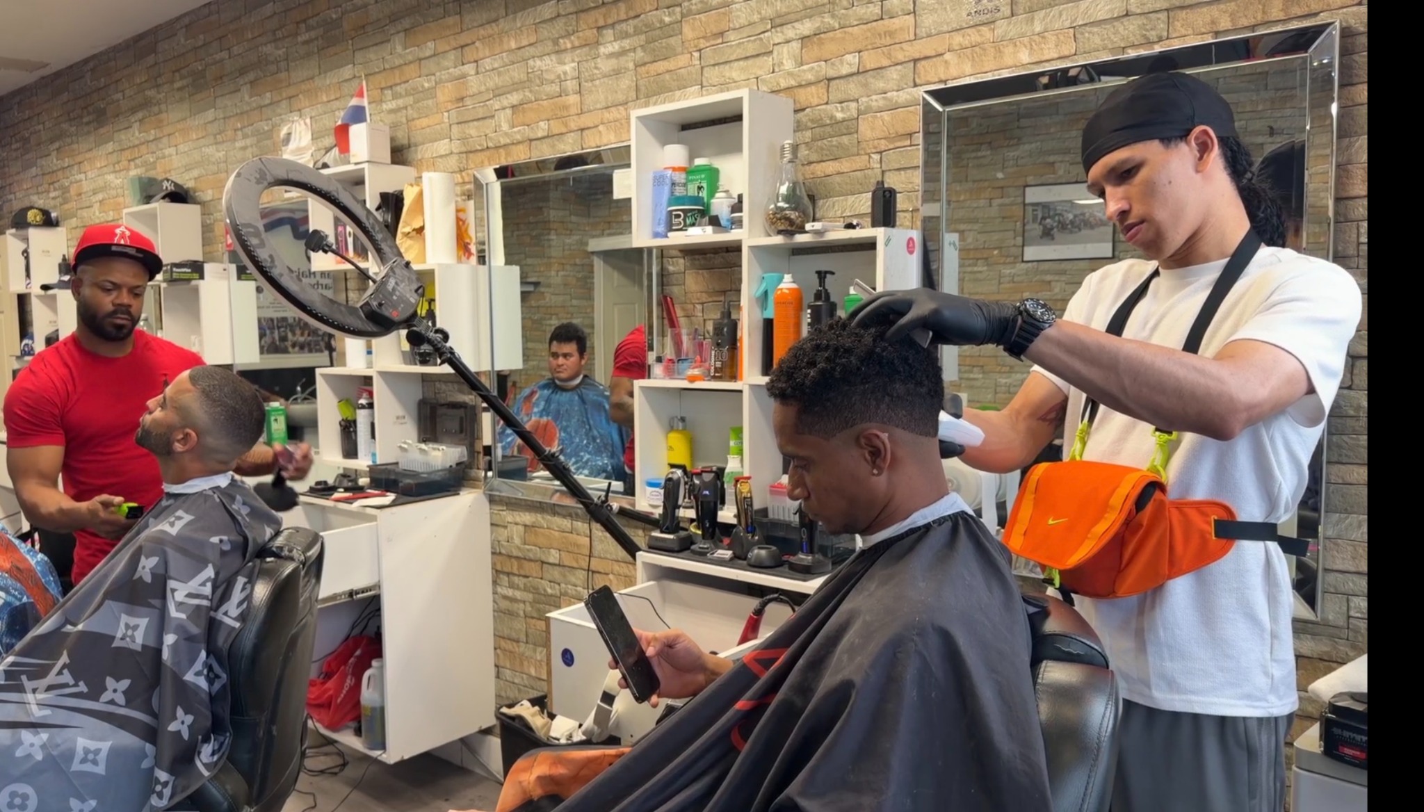 Barbers working with clients inside Looney Tunes Barbershop